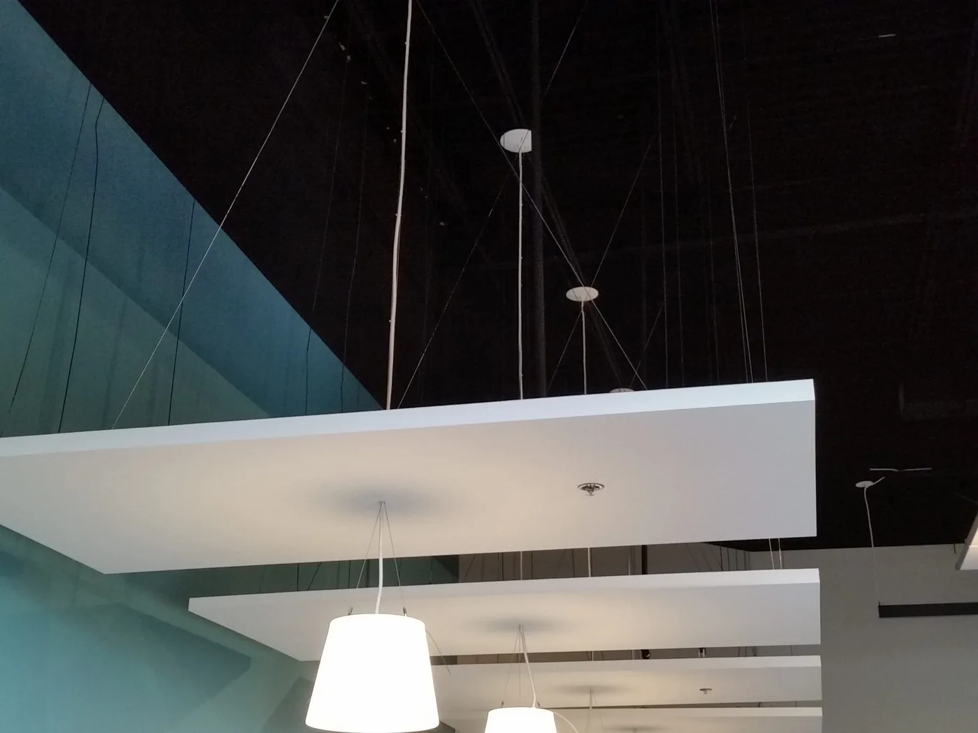 Suspended acoustic ceiling clouds in a commercial space