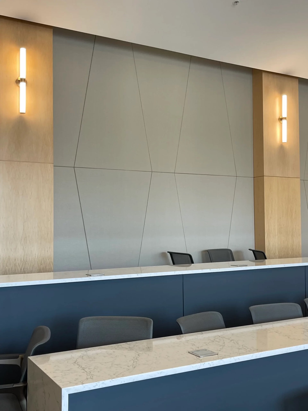 Angular acoustic wall panels integrated between wood columns in a commercial interior