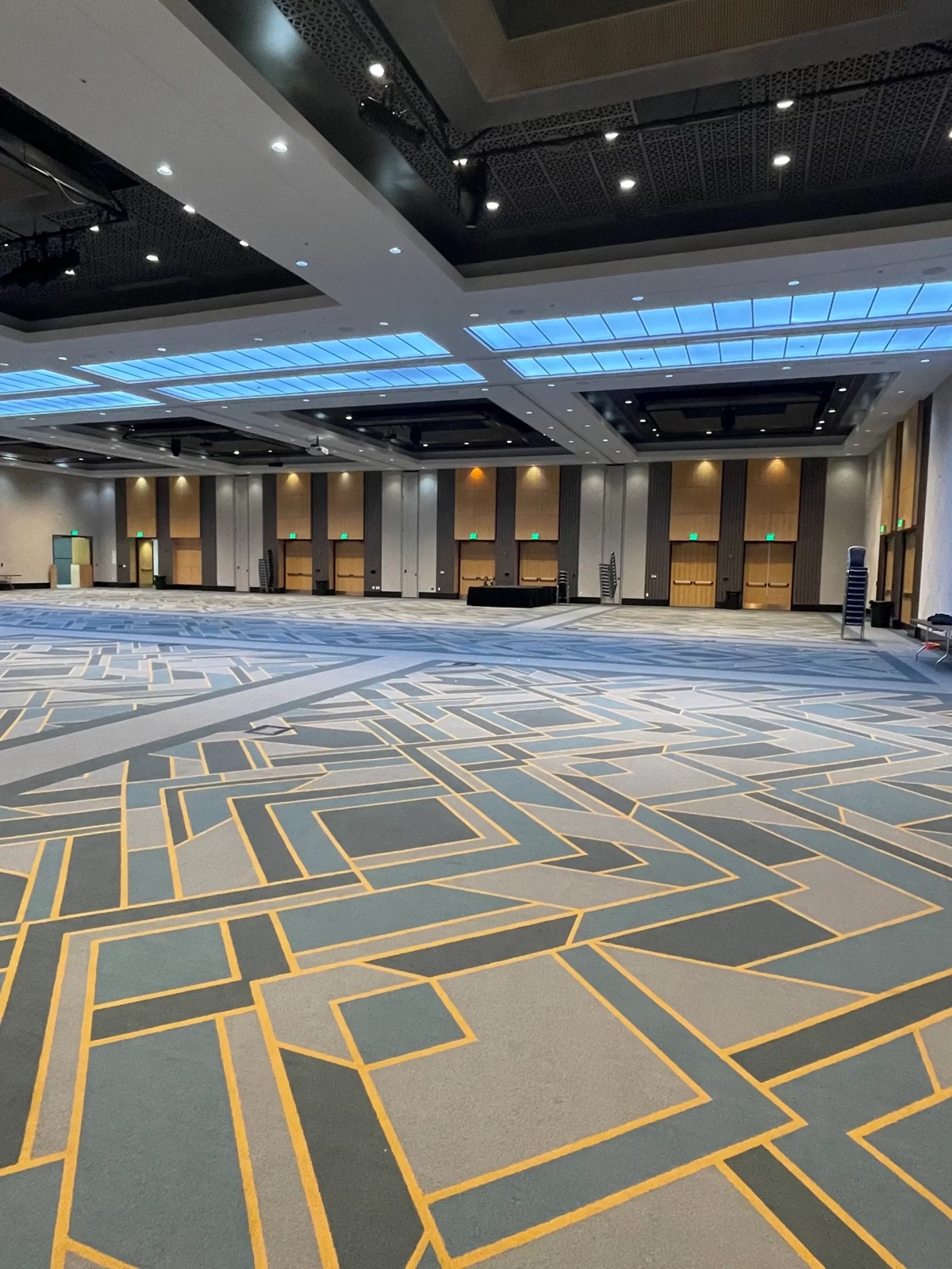 Finished ballroom with patterned wall panels and illuminated ceiling features