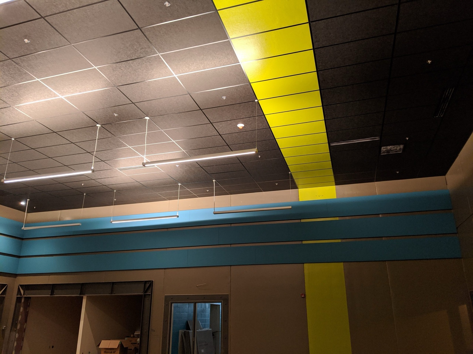 Alternating acoustic ceiling treatments coordinated with lighting in a large commercial interior