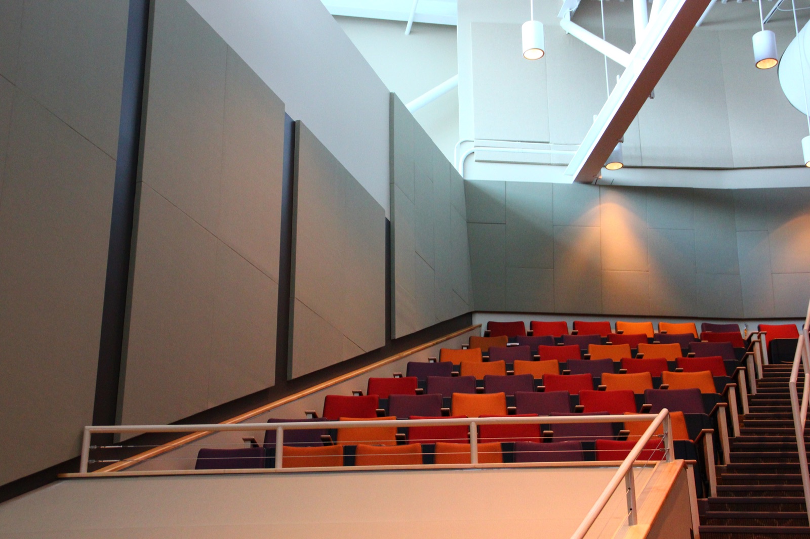 Large gray acoustic wall panels framing tiered seating in a commercial auditorium
