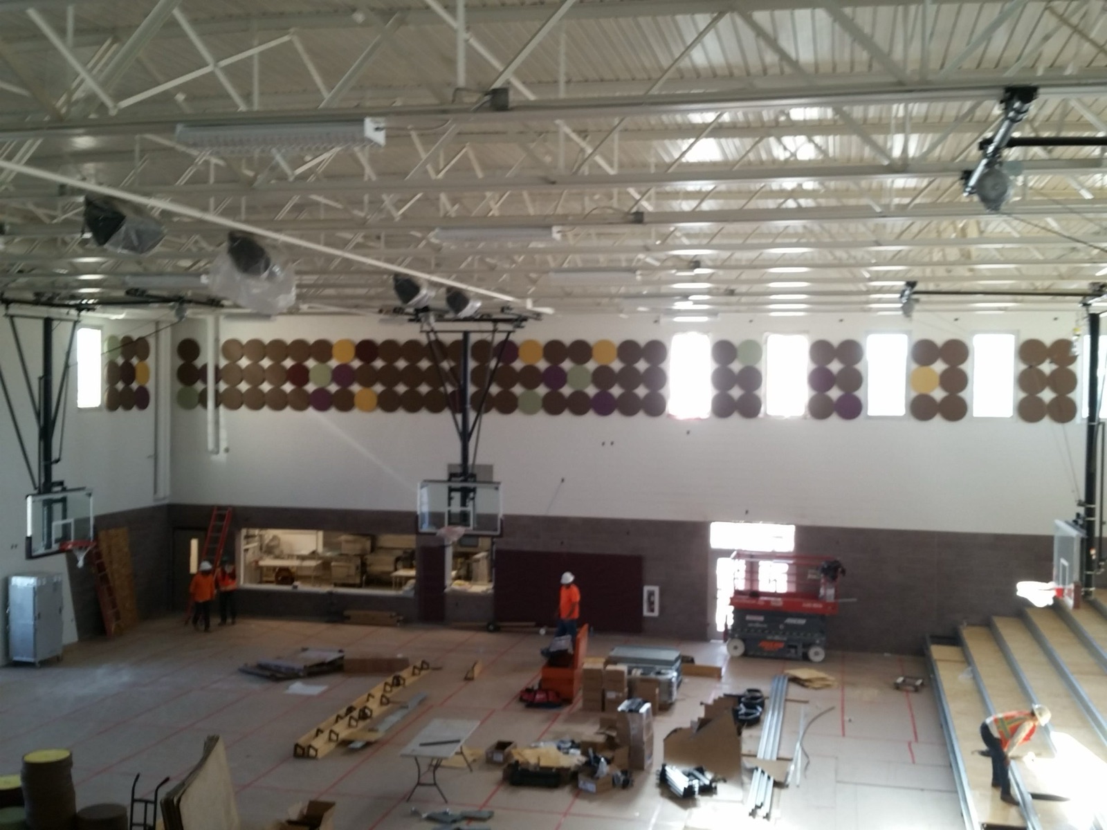Circular acoustic wall panels beside gymnasium bleachers