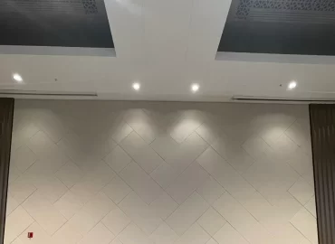Gray herringbone-pattern acoustic treatment across a finished wall.