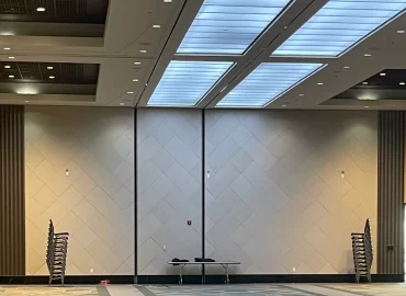 Full-height patterned wall treatment below large ceiling lights.