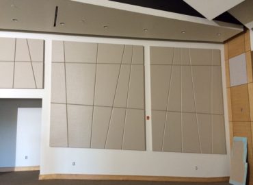 Irregular gray wall panels arranged within a white framed wall.