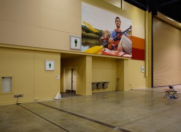 Photo graphics and gray wall panels above doors in a large hall.