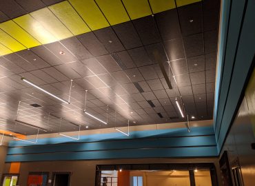Black, yellow and blue ceiling treatment with integrated lighting.