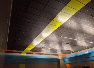 Black and yellow ceiling panels above blue wall treatment.
