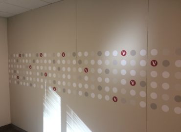 Grid of small circular panels arranged across a white wall.