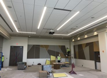 Gray and brown geometric wall panels in a room under construction.
