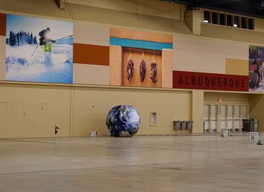 Wide public hall with photo murals and orange horizontal wall panels.