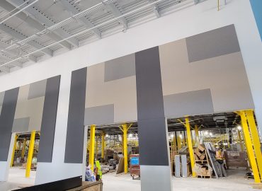 Gray rectilinear wall-panel composition in an industrial interior.