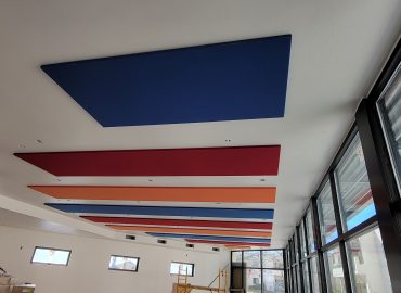 Long sequence of colored ceiling panels above a window wall.
