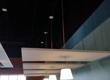 White horizontal ceiling clouds in a bright commercial interior.