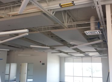White and gray ceiling baffles across an open commercial room.