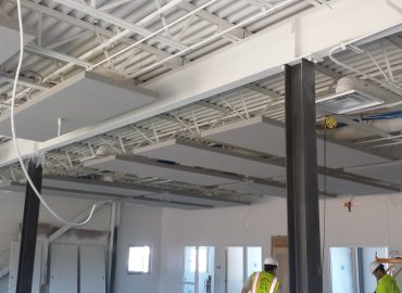 Gray rectangular ceiling clouds integrated within exposed structure.