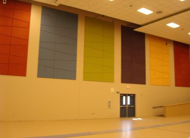 Tall red, gray, green and blue wall panels in a gymnasium.