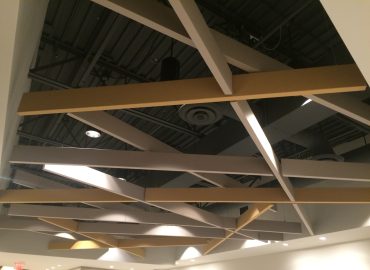 Angular acoustic baffles suspended across a finished interior.