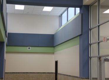 Blue and green horizontal wall panels in a gymnasium.