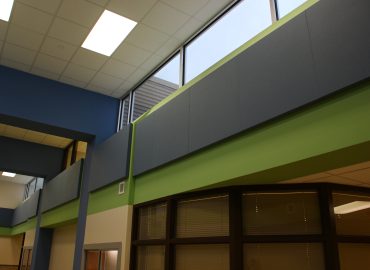 Blue and green horizontal acoustic panels above interior doors.