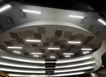 Circular ceiling feature with gray patchwork panels and integrated lights.