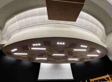 Round ceiling element with hanging brown baffles and gray panels.